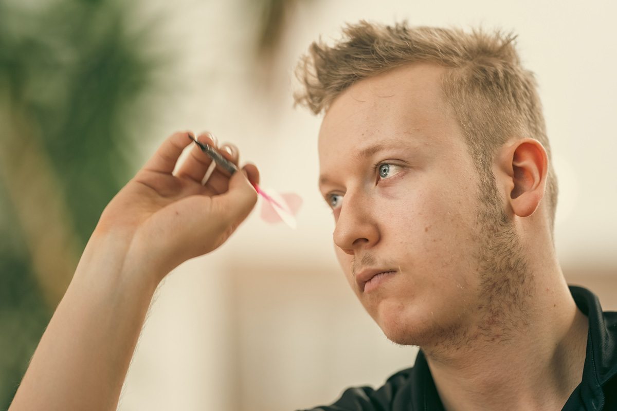 Dartspieler beim Wurf