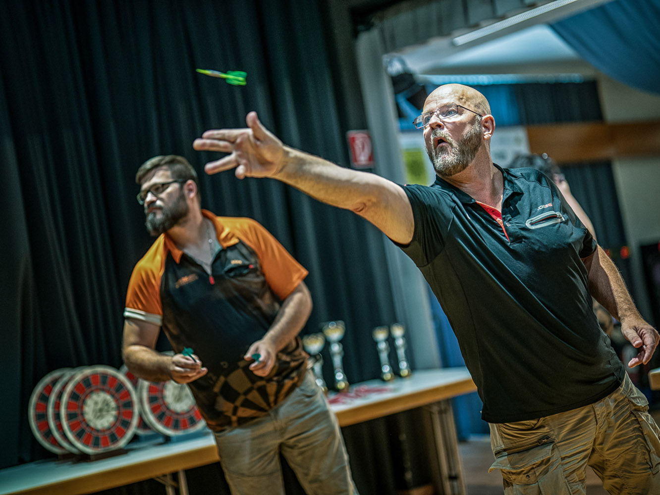 Dartspieler im Moment des Abwurfs